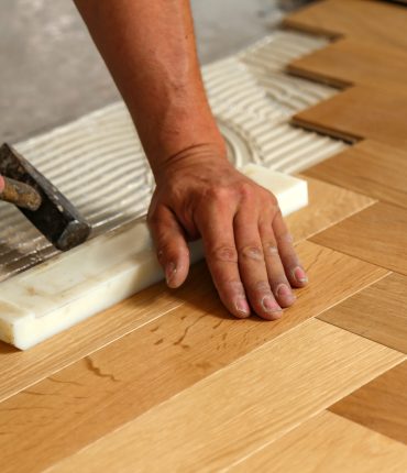 A worker installing parquet flooring